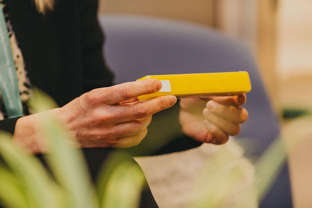 A person's hands holding a yellow box