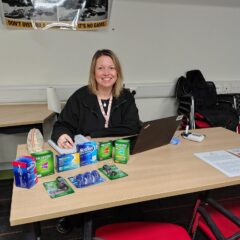 Maria sits at a table with stop smoking NRT products