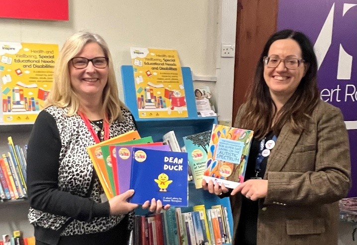 A photo of two ladies holding books