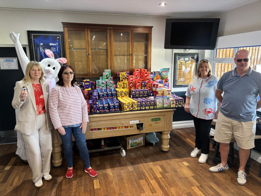A collection of over 100 Easter Eggs on a table with the Easter Bunny, Ann-Marie Matson and 3 foster carers