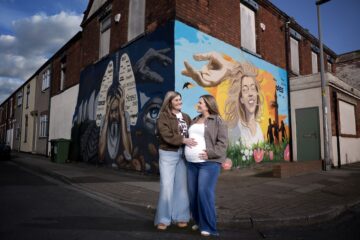 Wendy and her daughter Amy stand in front of the smoking mural on the corner of a Grimsby street