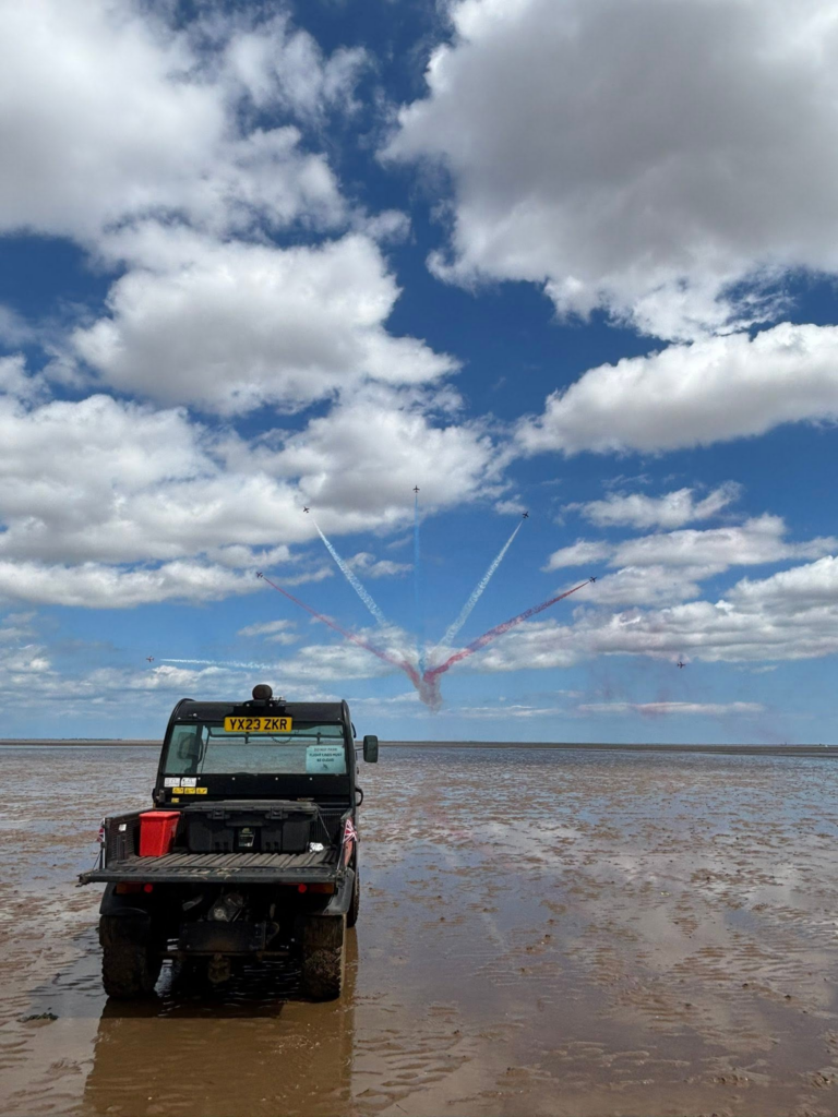 Beach buggy on beach with planes in background
