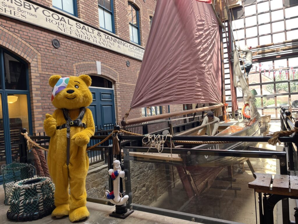 Pudsey Bear in front of Perseverence at Grimsby Fishing Heritage Centre
