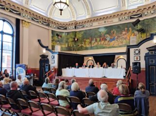 an audience of residents sat in front of a table of Cabinet members