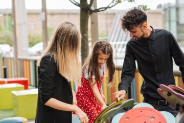 Mum and dad on playground with daughter